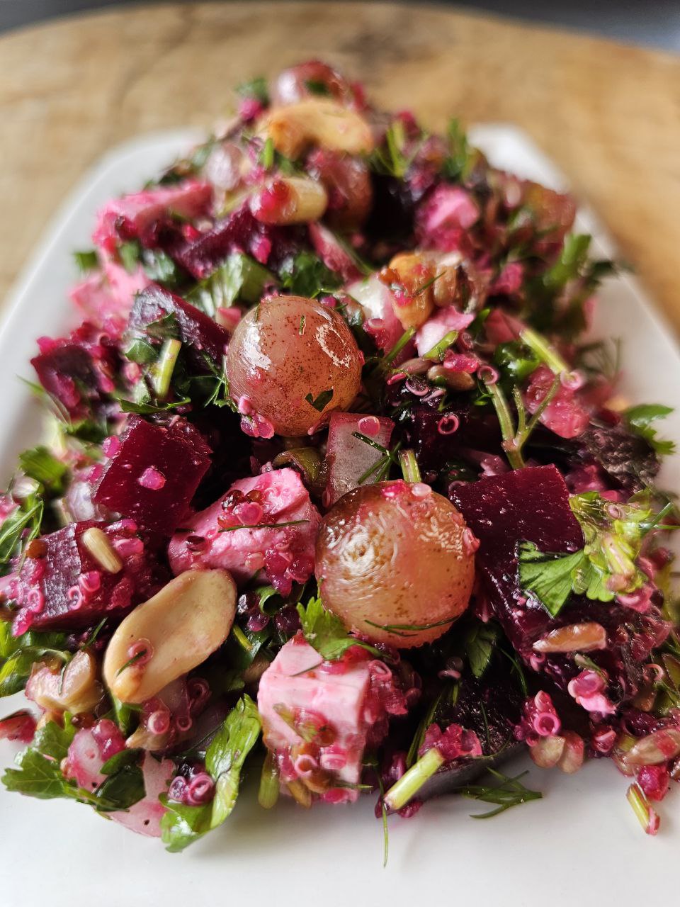 Frischer Rote-Bete-Salat mit Quinoa, gegrillten Weintrauben, gerösteten Nüssen und Feta, angerichtet mit einem süß-säuerlichen Dressing