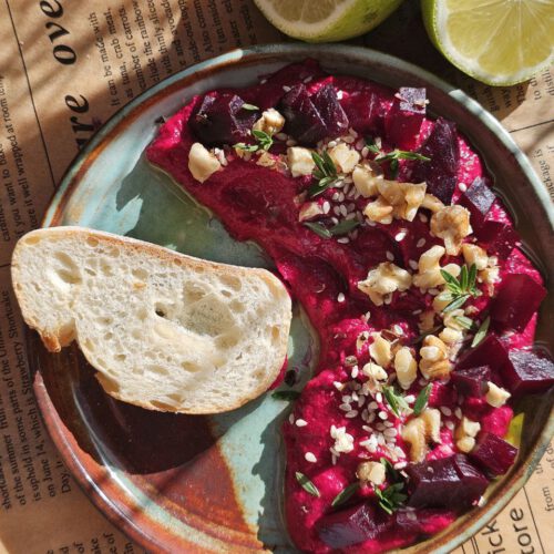 Rote Bete Hummus – Der Ultimative Power-Dip, garniert mit frischen Kräutern und Granatapfelkernen.