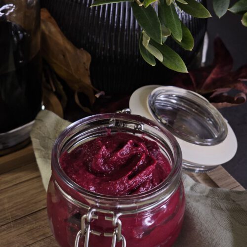 Rote Bete Hummus, ein leuchtend pinker, veganer Dip aus Kichererbsen und Roter Bete, garniert mit frischen Kräutern und Granatapfelkernen.