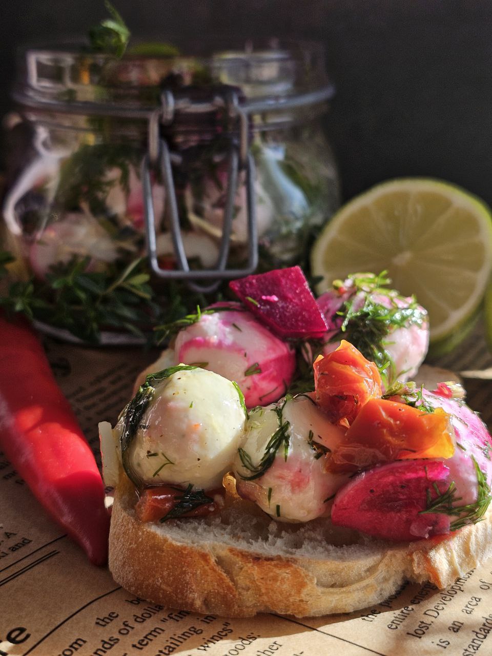 Marinierte Mozzarella oder Feta in einer aromatischen Kräutermarinade mit Olivenöl, Knoblauch und getrockneten Tomaten, serviert als Antipasti auf einem frischen Baguette – perfekt als Beilage zum Grillen oder für gesunde Snacks.