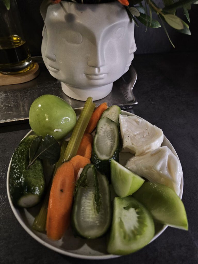 Fermentiertes Gemüse in einem Glas mit Dill, Pfefferkörnern und Lorbeerblättern,