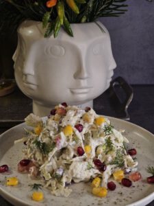 Krautsalat mit Hähnchenbrust, Granatapfelkernen und Walnüssen, serviert in einer Schüssel – gesunde und farbenfrohe Mahlzeit mit cremigem Joghurtdressing