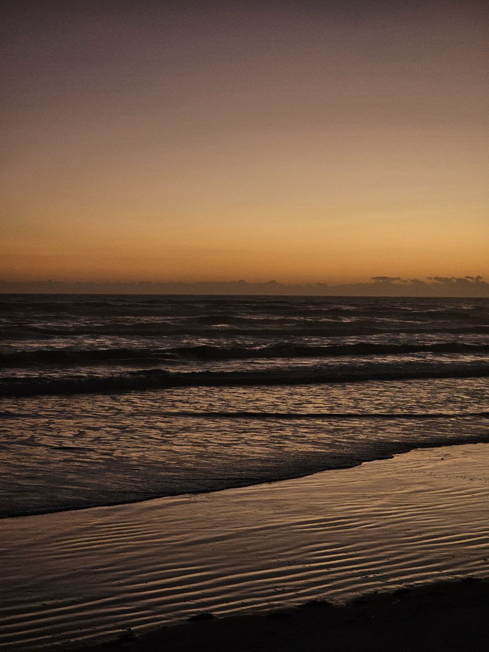 New Smyrna Beach, Florida, mit sanften Wellen und atemberaubendem Sonnenaufgang – ein ruhiges Urlaubsparadies.