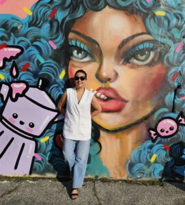 a woman standing in front of a mural in Littel Havana ,Miami