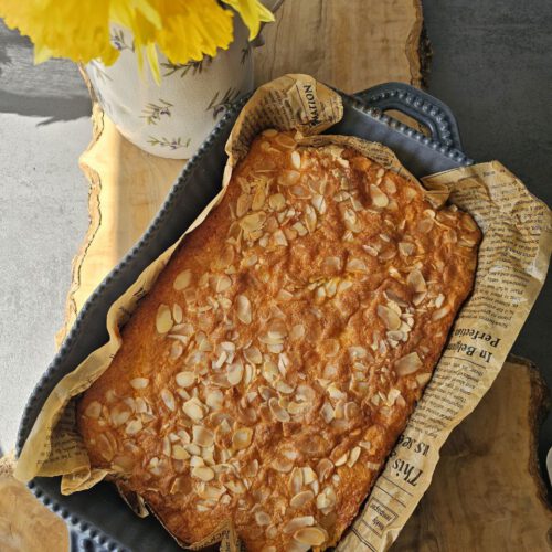 Detailaufnahme eines Stücks Möhrenkuchen – saftige Konsistenz mit geraspelten Möhren und Mandeln sichtbar