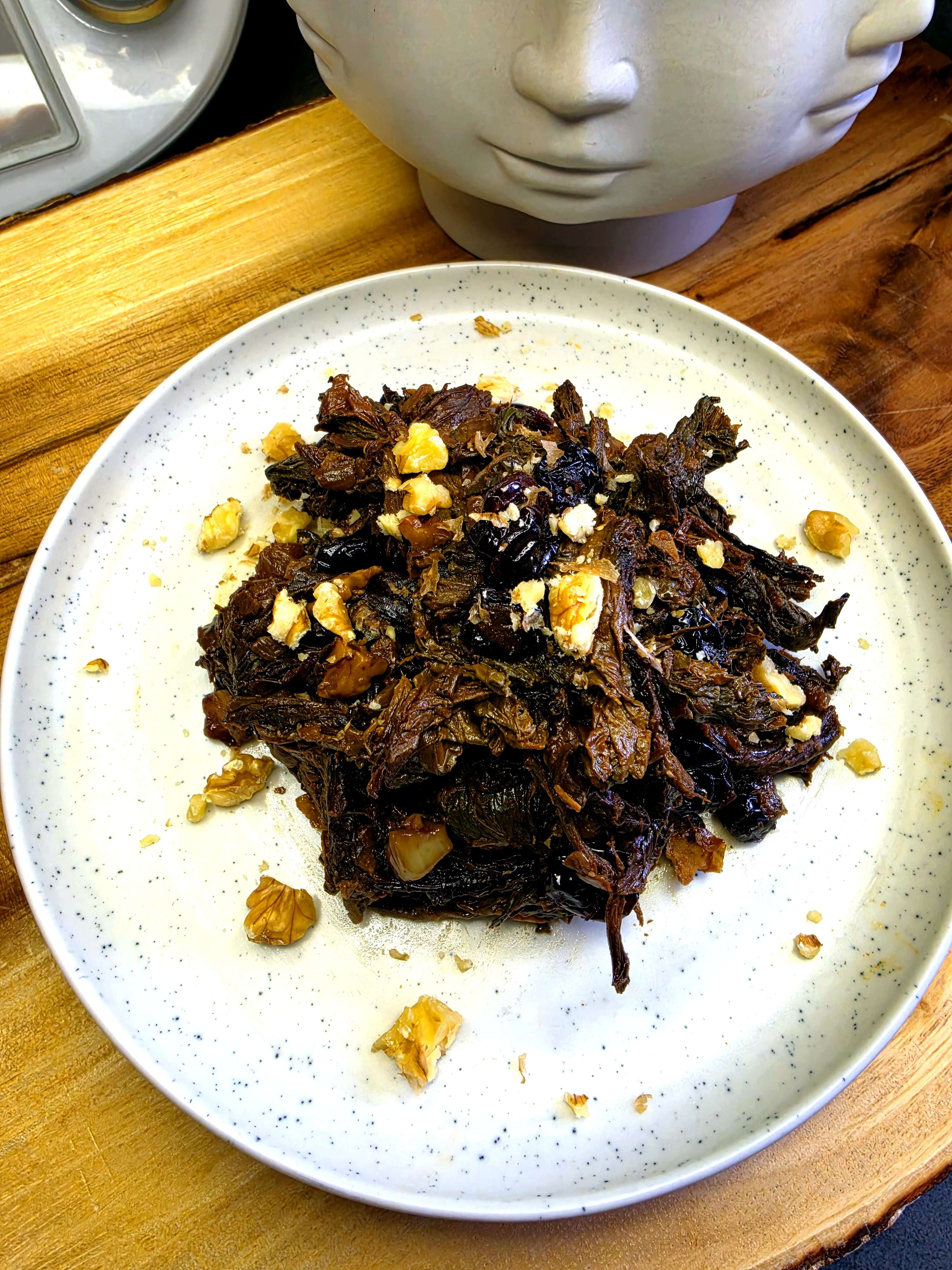 Aveluk-Salat mit Walnüssen und Cranberries auf weißem Teller angerichtet