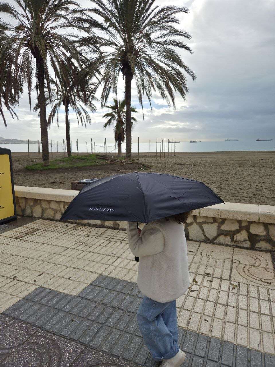 Málaga: Tipps für eine entspannte Städtereise in Andalusien 7 Málaga: Tipps für eine entspannte Städtereise in Andalusien Strand von Málaga im Februar bei Regenwetter mit Regenschirm
