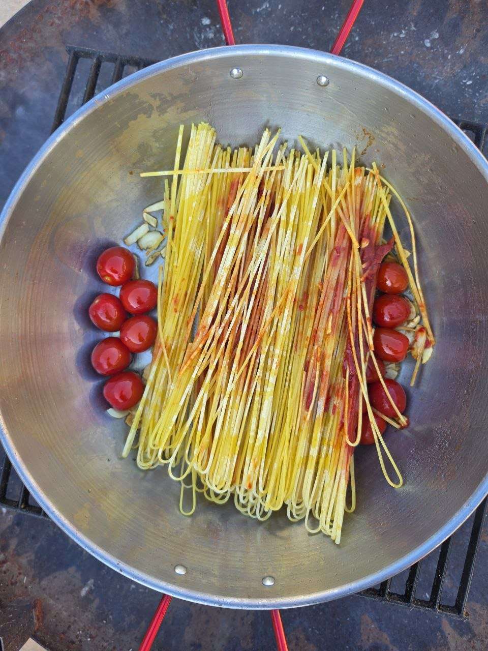 Rohe Spaghetti all'assassina mit Kirschtomaten und Knoblauch in der Eisenpfanne