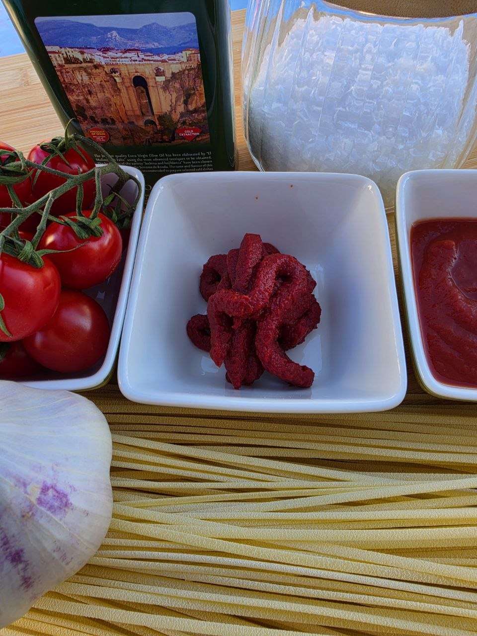 Zutaten für Spaghetti all'assassina: Tomaten, Tomatenmark, Passata, Knoblauch und Olivenöl
