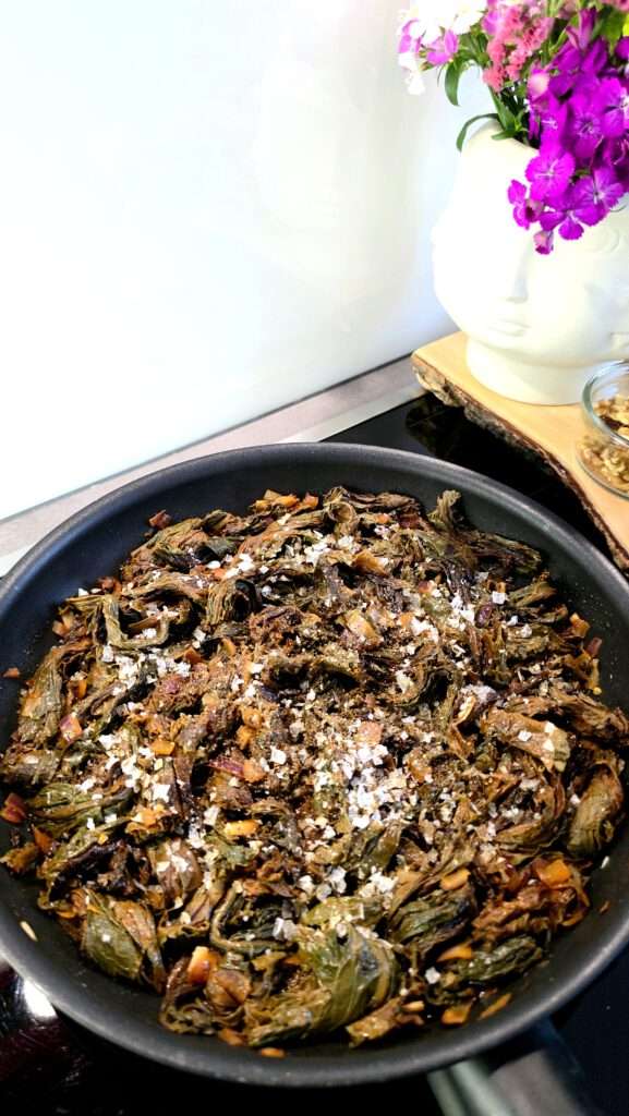 Aveluk-Salat in der Pfanne mit Meersalz bestreut, dekoriert mit Blumen