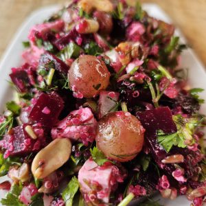 Frischer Rote-Bete-Salat mit Quinoa, gegrillten Weintrauben, gerösteten Nüssen und Feta, angerichtet mit einem süß-säuerlichen Dressing