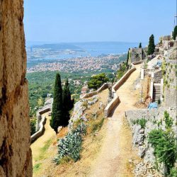 Historische Festung Klis in Kroatien, hoch auf einem Bergkamm gelegen, mit Panoramablick auf die Umgebung.